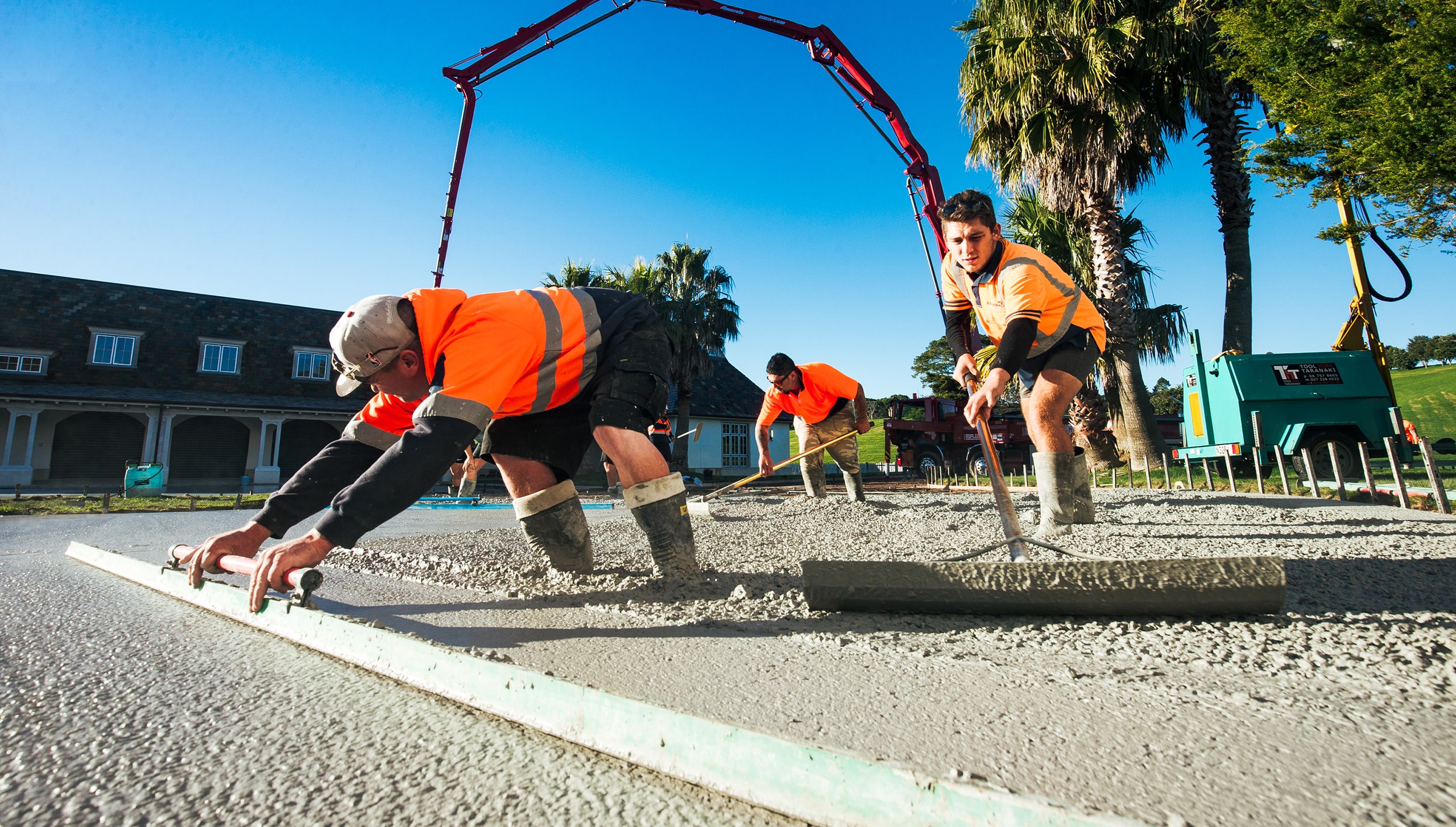 concrete layers working pouring a large area of concrete outdoors.