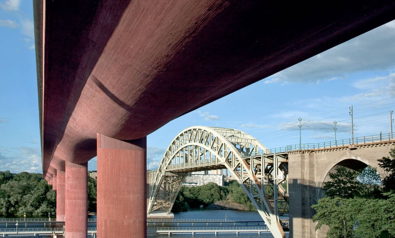 the underside of a motorway bridge made of bright red coloured concrete.